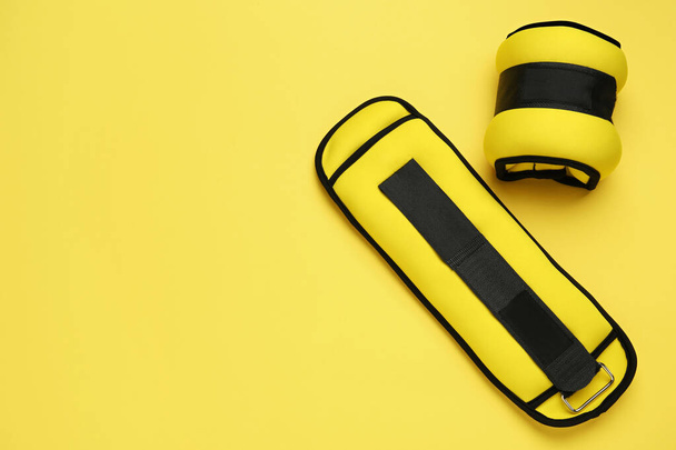 Stylish weighting agents on yellow background, flat lay. Space for text - Fotó, kép