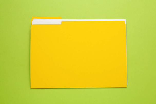 Yellow file with documents on light green background, top view - Fotoğraf, Görsel