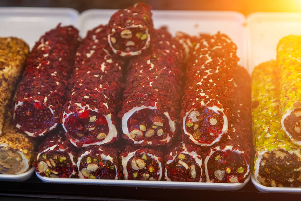 Beliebtes süßes türkisches Essen - Stapel türkischer Köstlichkeiten mit Nüssen aus Früchten auf dem Straßenmarkt in der Türkei - Foto, Bild