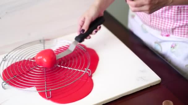 A séf spatulát és kést használ, hogy eltávolítsa a felesleges jeget a szív alakú tortából. - Felvétel, videó