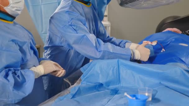 Cirugía vascular en clínica moderna. herida en el brazo. Cirujanos que utilizan herramientas quirúrgicas durante la operación venas varicosas, Radiólogo realiza la operación endovascular con la máquina de angiografía. Cardio-vascular - Imágenes, Vídeo