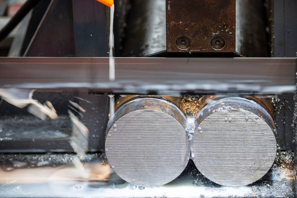 La máquina automática de sierra de cinta corta la barra de metal con el método de refrigerante de base de agua. La máquina herramienta para uso industrial. - Foto, Imagen