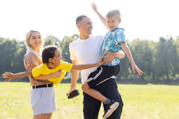 happy family playing in the green field - Φωτογραφία, εικόνα