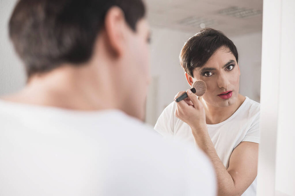 Homosexuál si před zrcadlo nanáší make-up. Mužský transgender. - Fotografie, Obrázek