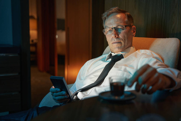 Portrait of businessman resting at hotel room after hard day - Foto, Bild