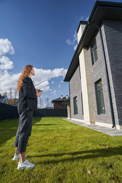 Female engineer is inspecting house from lawn - Foto, Bild