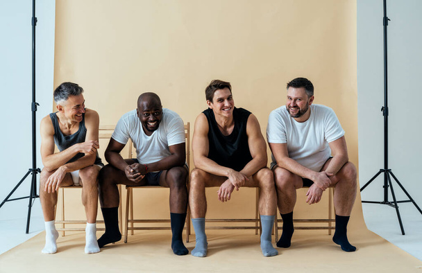 group of multiethnic men posing for a male edition body positive beauty set. guys with different age, and body wearing boxers underwear - Foto, Bild