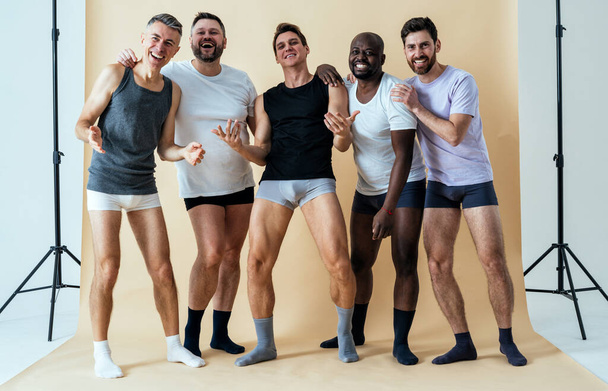 group of multiethnic men posing for a male edition body positive beauty set. guys with different age, and body wearing boxers underwear - Valokuva, kuva