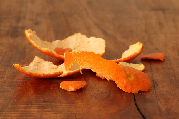 Tangerine δέρμα σε ένα ξύλινο φόντο. Mandarin περιέχει ευεργετικά στοιχεία και μέταλλα.  - Φωτογραφία, εικόνα