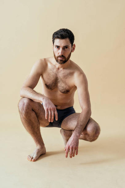 man posing for a male edition body positive beauty set. Shirtless guy wearing boxers underwear in studio - Foto, imagen
