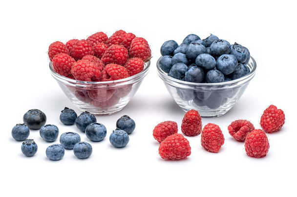 Fresh raspberries and blueberries in glass bowls isolated on white background. Berries in bowl. - Photo, Image