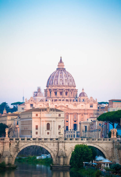 ΡΩΜΗ, ΙΤΑΛΙΑ - ΙΟΥΝΙΟΣ 2020: Πανόραμα ηλιοβασιλέματος στη γέφυρα του ποταμού Τίβερη με φόντο τον τρούλο του καθεδρικού ναού του Αγίου Πέτρου (Πόλη του Βατικανού) - Ρώμη, Ιταλία - Φωτογραφία, εικόνα