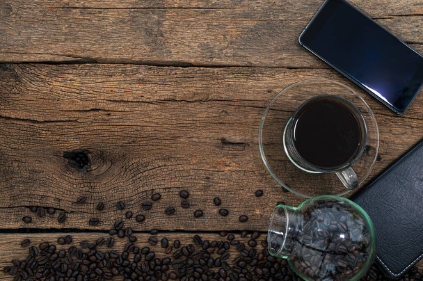 A top view of a smartphone and coffee on a wooden desk - Photo, image