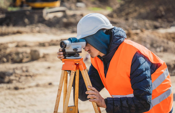 Surveyor worker with theodolite equipment at construction site - 写真・画像