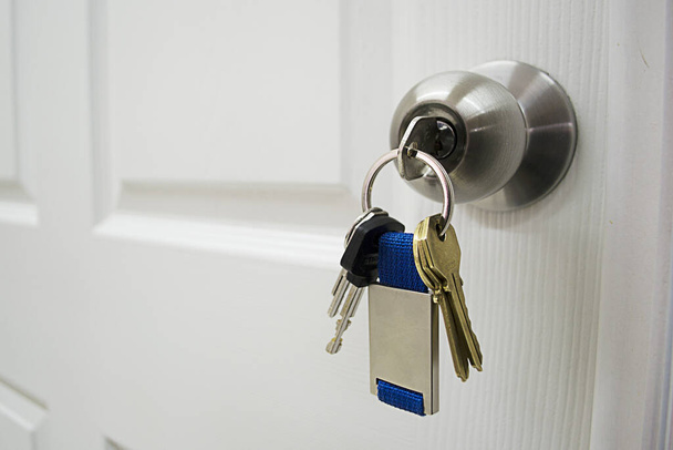 A closeup of a Keys in a latch opening or closing a door - Fotó, kép