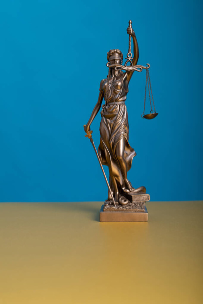 A vertical shot of a statue of justice holding scales - Foto, Bild