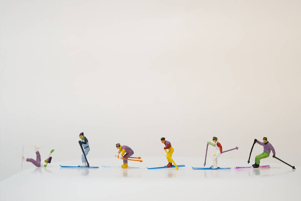 Eine Gruppe von Miniaturfiguren von Skifahrern auf weißem Hintergrund - Foto, Bild