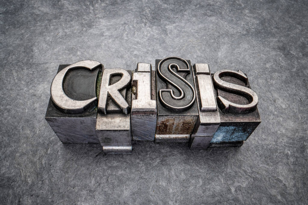 crisis word abstract in gritty vintage letterpress metal types, mixed fonts against handmade bark paper, trouble, emergency or trauma concept - Foto, afbeelding