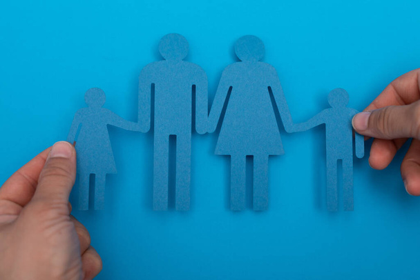 An overhead of a person holding paper family figures - Foto, imagen