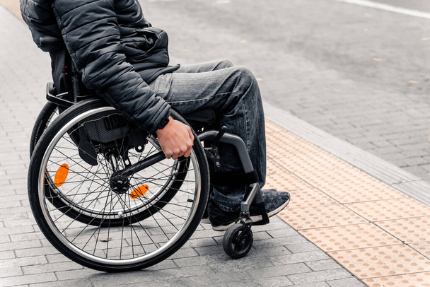 Person with a physical disability waiting for city transport with an accessible ramp. - Foto, Imagen