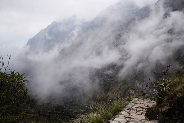 Pohled na krajinu tohoto mlhavého rána v horách. Nízké mraky na horách And a bez lidí na slavné stezce Inca v Peru, Jižní Americe. - Fotografie, Obrázek