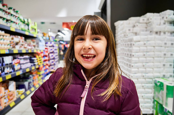 venta, consumismo y concepto de personas - niña feliz con comida en el carrito de la compra en la tienda de comestibles o supermercado sobre nieve
 - Foto, imagen