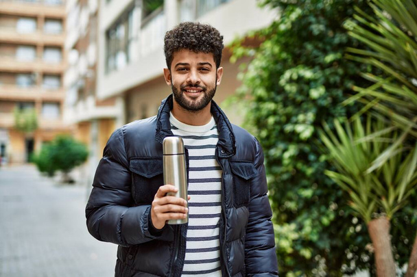 Young arab man holding coffee thermo outdoor at the town - Foto, Imagem