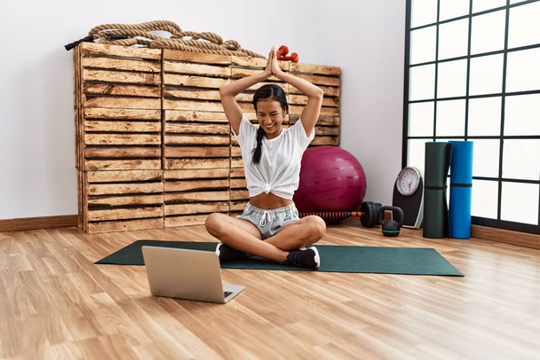 Junge lateinamerikanische Frau mit Online-Yoga-Kurs im Sportzentrum - Foto, Bild