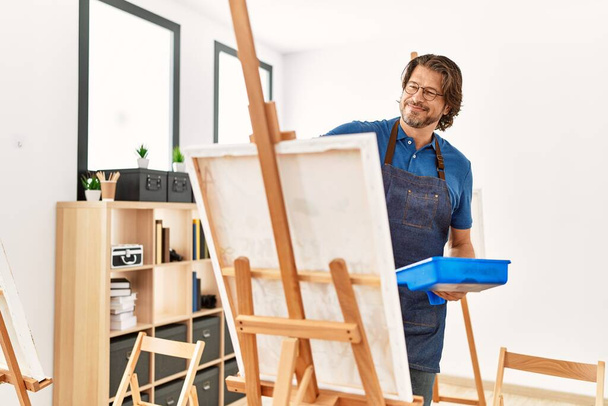 Middle age caucasian man smiling confident drawing at art studio - Фото, изображение