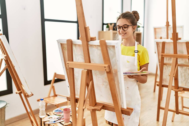 Entzückendes Mädchen lächelt selbstbewusst Zeichnung im Kunstatelier - Foto, Bild