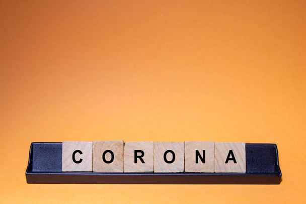 Coronavirus. Covid-19 written with letters. Orange background and space for text. Horizontal photography. - Valokuva, kuva