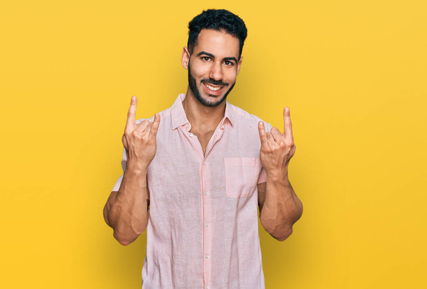 Hispanic man with beard wearing casual shirt shouting with crazy expression doing rock symbol with hands up. music star. heavy concept.  - Фото, зображення