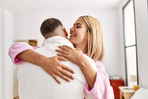 Young caucasian couple smiling happy and hugging standing at bedroom. - Photo, Image