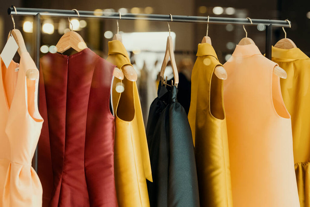 έννοια ψώνια - πολύχρωμα ρούχα σε ένα φανταχτερό κατάστημα - Φωτογραφία, εικόνα
