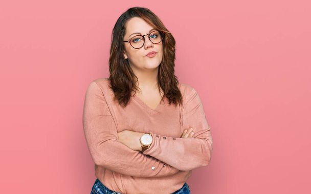 Young plus size woman wearing casual clothes and glasses skeptic and nervous, disapproving expression on face with crossed arms. negative person.  - Fotó, kép