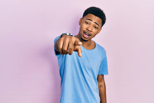 Young african american man wearing casual blue t shirt pointing displeased and frustrated to the camera, angry and furious with you  - Photo, Image