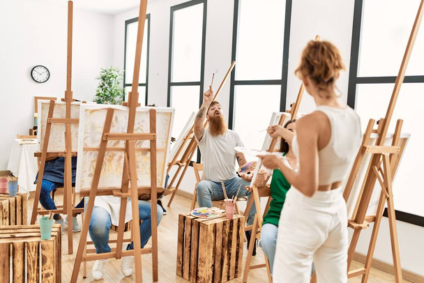 Ομάδα ανθρώπων χαμογελώντας χαρούμενη ζωγραφική στο μάθημα ζωγραφικής στο στούντιο τέχνης. - Φωτογραφία, εικόνα