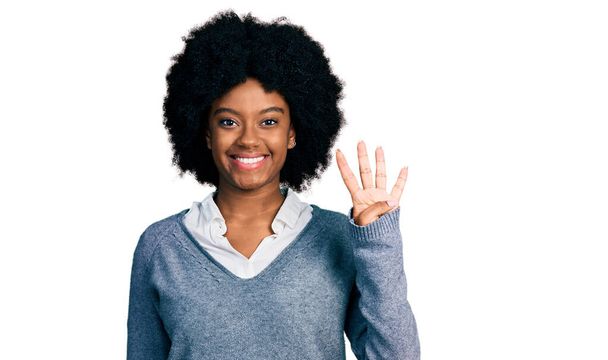 Nuori afrikkalainen amerikkalainen nainen yllään liikevaatteita näy ja osoittaa sormella numero neljä hymyillen itsevarma ja onnellinen.  - Valokuva, kuva