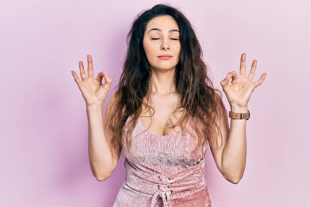 Young hispanic woman wearing casual clothes relax and smiling with eyes closed doing meditation gesture with fingers. yoga concept.  - Photo, Image