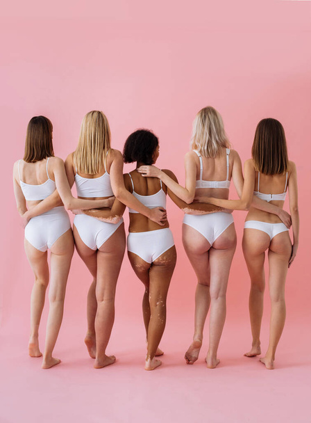 Happy pregnant women with big bellies and beautiful mothers posing in studio - Multiracial group of positive pregnant women and moms wearing underwear - Pregnancy, motherhood, people, body positive and body acceptance concept - Foto, afbeelding