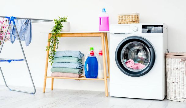 Washing machine with laundry in bathroom - Fotó, kép
