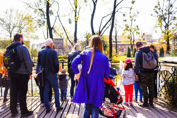 POZNAN, POLAND - Apr 07, 2019: A group of people watching animals from behind a barrier in the old zoo. - Фото, зображення
