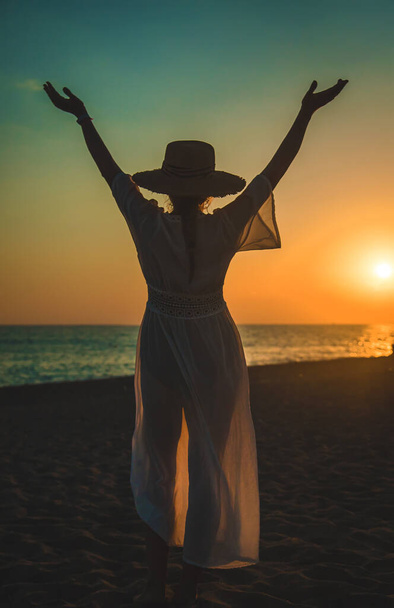 Жінка на пляжі на заході сонця. Вибірковий фокус. море
. - Фото, зображення