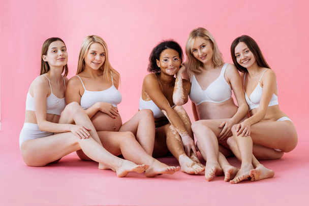 Happy pregnant women with big bellies and beautiful mothers posing in studio - Multiracial group of positive pregnant women and moms wearing underwear - Pregnancy, motherhood, people, body positive and body acceptance concept - Valokuva, kuva
