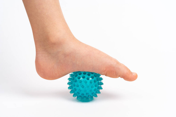 Masaj için mavi iğne topu ve çocuk ayaklı beyaz bir arka planda fizik tedavi, ayak valesinin önlenmesi ve tedavi konsepti - Fotoğraf, Görsel