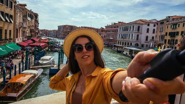 Travel influencers Venice island. Paint building house in Europe Venezia city. Photographer blogger girl with smartphone in Venice San Marco square. Traveling and freelancing, modern lifestyle - Photo, Image