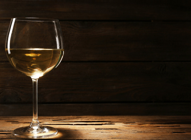 Goblet of white wine on wooden table on wooden wall background - Foto, Bild
