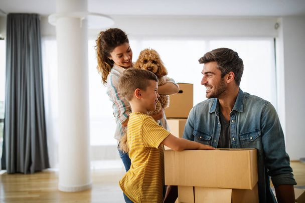 Happy family unpacking boxes in new home on moving day. People, real estate, new home concept - Foto, imagen