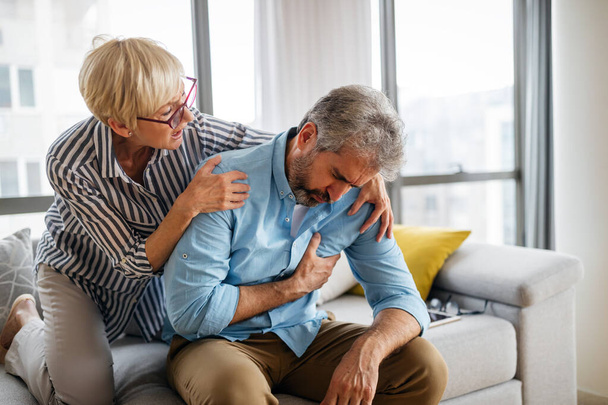 Senior woman comforting elderly man with depression, health problem, stress at home - Foto, afbeelding