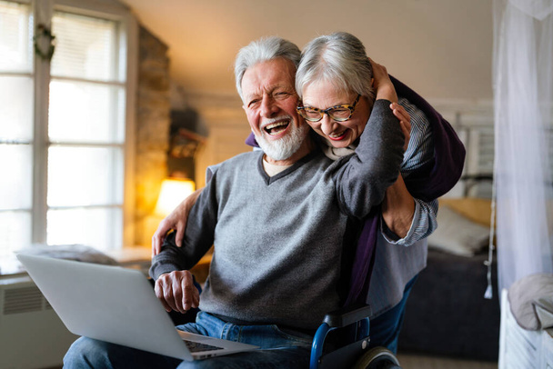 Happy senior couple using laptop at home and having fun together. Technology people concept - Photo, Image
